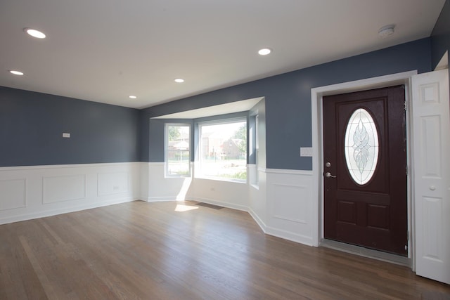 entrance foyer featuring a wainscoted wall, dark wood finished floors, recessed lighting, and a decorative wall