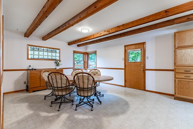 tiled dining area featuring beam ceiling