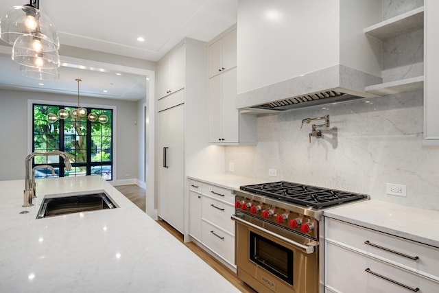 kitchen featuring premium appliances, white cabinets, light stone counters, and custom range hood