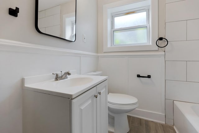 full bathroom featuring hardwood / wood-style flooring, vanity, plus walk in shower, and toilet