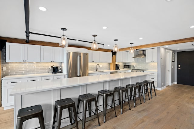 kitchen featuring a center island, stainless steel appliances, white cabinetry, a breakfast bar area, and pendant lighting