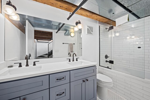 full bathroom with tile patterned flooring, toilet, tiled shower / bath combo, and vanity