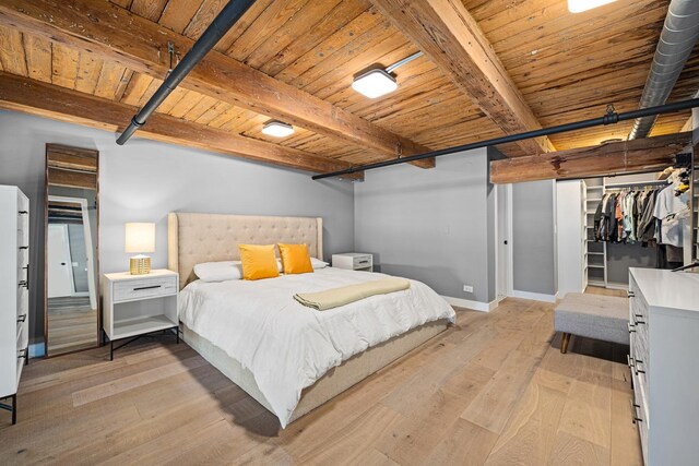 bedroom featuring light wood-type flooring, a closet, beam ceiling, and wooden ceiling