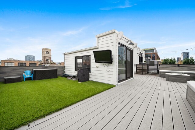 deck featuring a hot tub and a yard