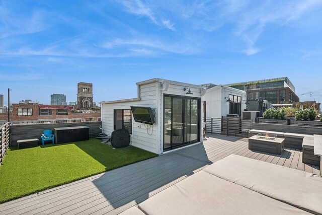 wooden terrace with a yard and a fire pit