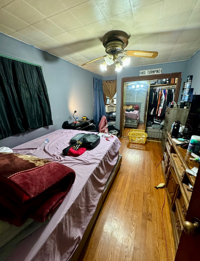 bedroom featuring a closet, wood-type flooring, and ceiling fan