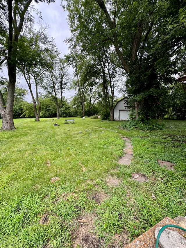 view of yard featuring a garage and an outdoor structure