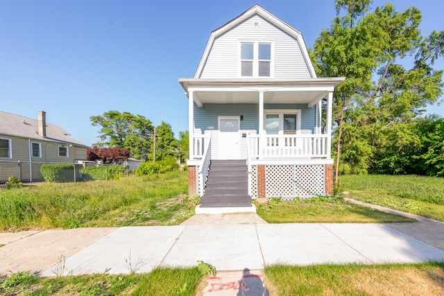 dutch colonial with fence, a porch, and a gambrel roof