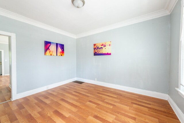 spare room with wood-type flooring and ornamental molding