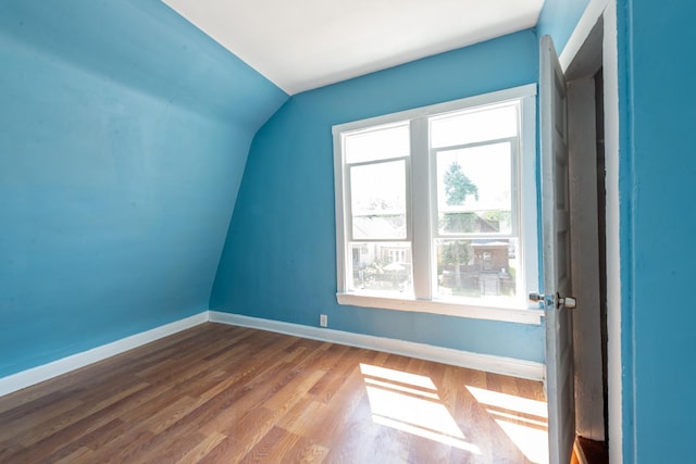 additional living space with baseboards, vaulted ceiling, and wood finished floors