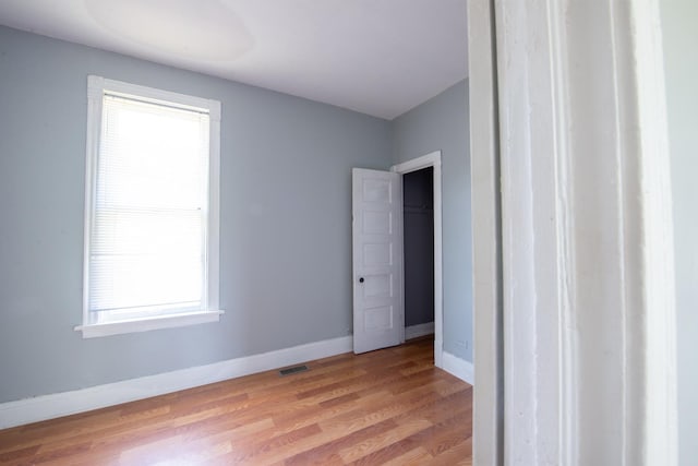 empty room featuring light wood-type flooring and baseboards