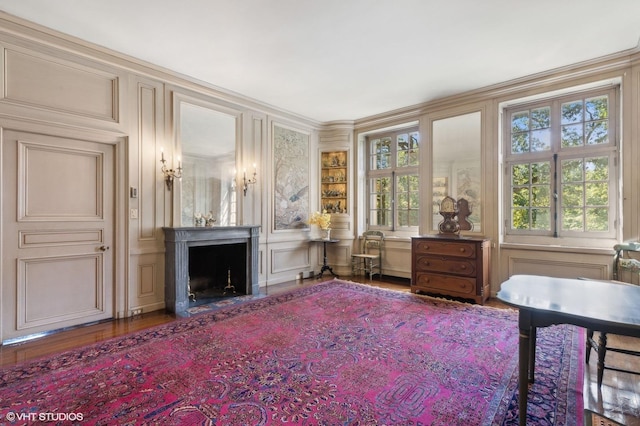 sitting room with a decorative wall, wood finished floors, and a fireplace