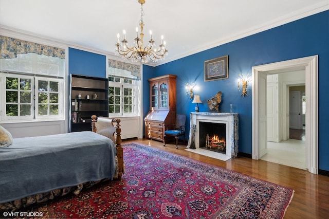 bedroom with multiple windows, an inviting chandelier, ornamental molding, and wood finished floors
