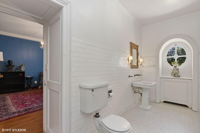 bathroom with ornamental molding, toilet, tile walls, wainscoting, and tile patterned flooring