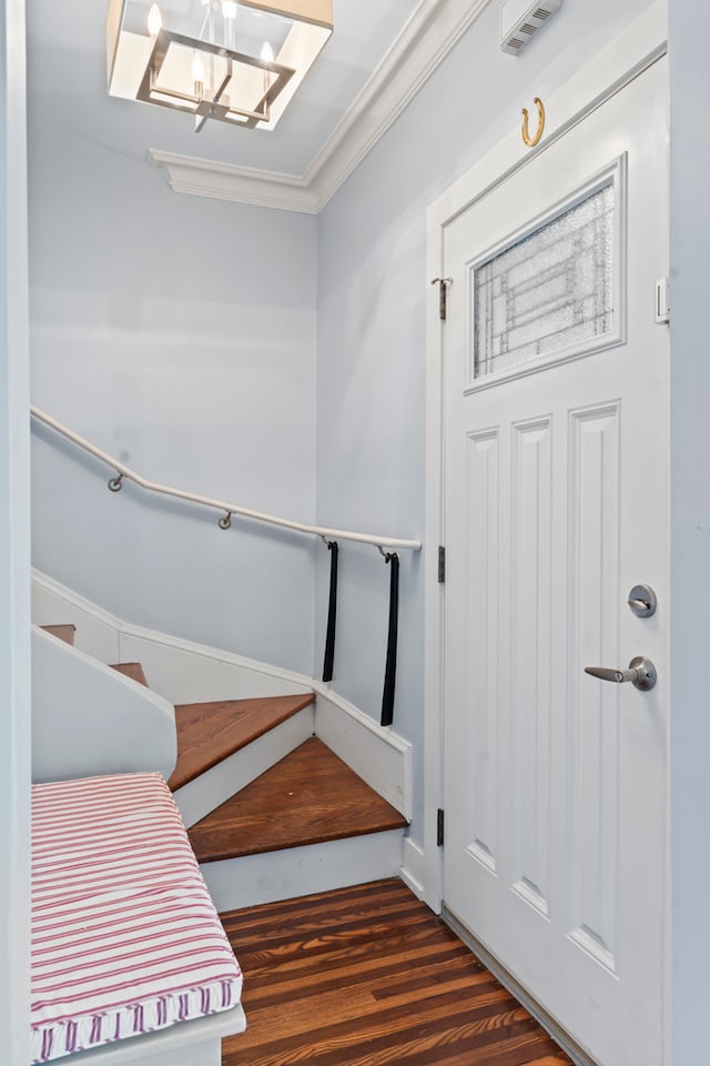 stairs with crown molding and hardwood / wood-style flooring