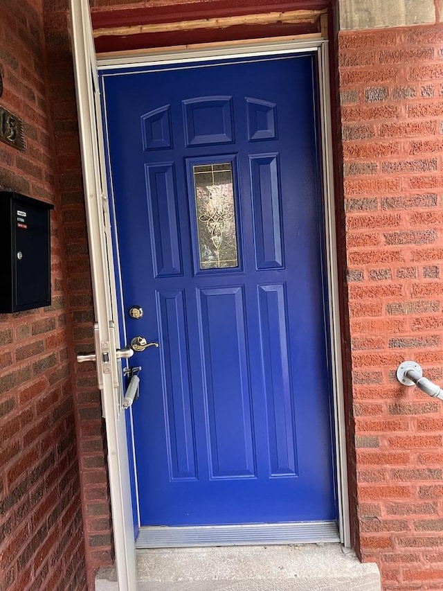 doorway to property with brick siding