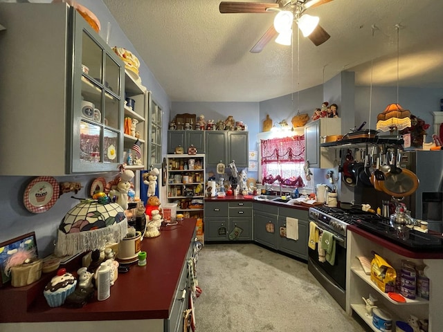 kitchen with sink, gas stove, light colored carpet, a textured ceiling, and ceiling fan