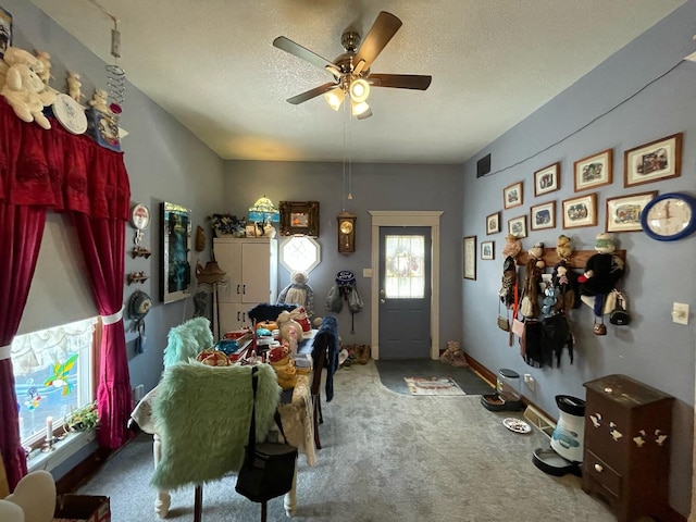 carpeted dining area with ceiling fan and a textured ceiling