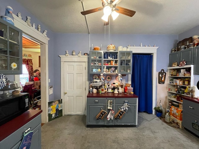 kitchen with ceiling fan, carpet floors, and a textured ceiling