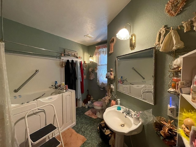 bathroom with sink, a bathtub, and toilet