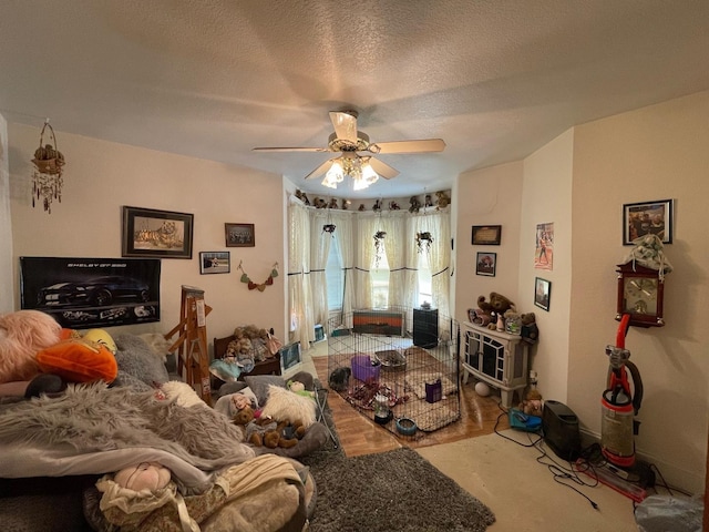 living room with ceiling fan and a textured ceiling