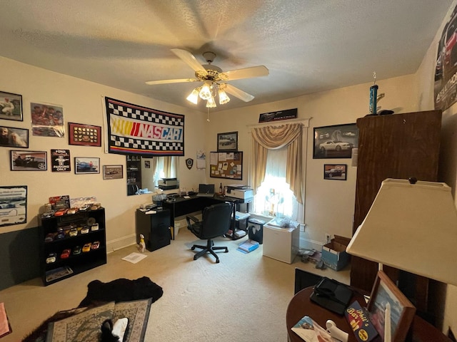 carpeted home office with ceiling fan and a textured ceiling