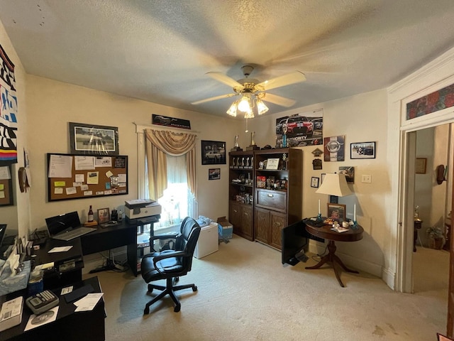 carpeted office space with ceiling fan and a textured ceiling