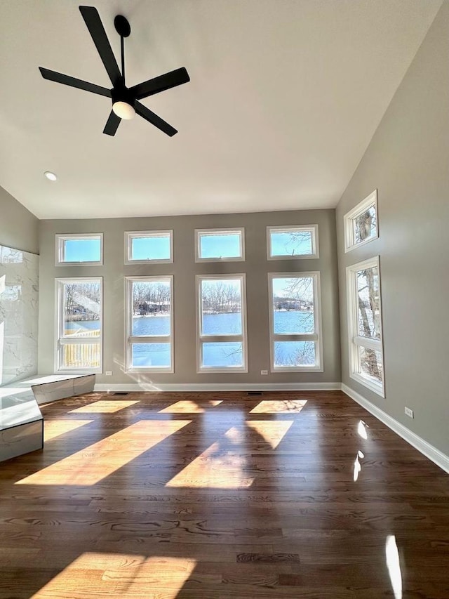 unfurnished living room featuring ceiling fan, a wealth of natural light, and hardwood / wood-style floors