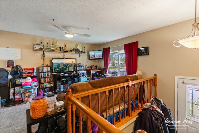 carpeted living room with ceiling fan and a textured ceiling