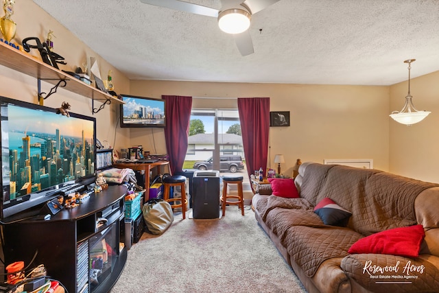 carpeted living room with ceiling fan and a textured ceiling