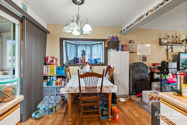 dining area featuring an inviting chandelier and hardwood / wood-style flooring