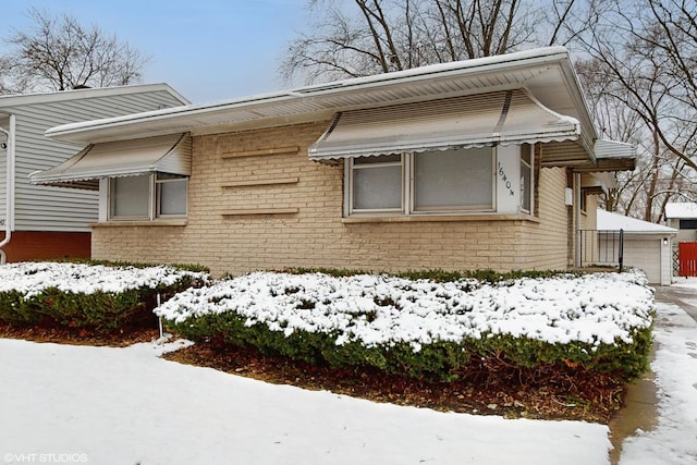 view of snowy exterior featuring a garage