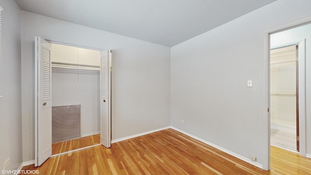 unfurnished bedroom with a closet and light hardwood / wood-style flooring