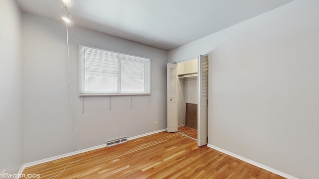 unfurnished bedroom featuring light wood-type flooring and a closet