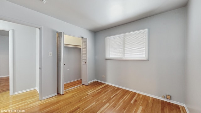 unfurnished bedroom with a closet and wood-type flooring