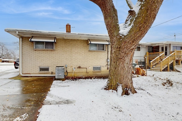 snow covered property with cooling unit