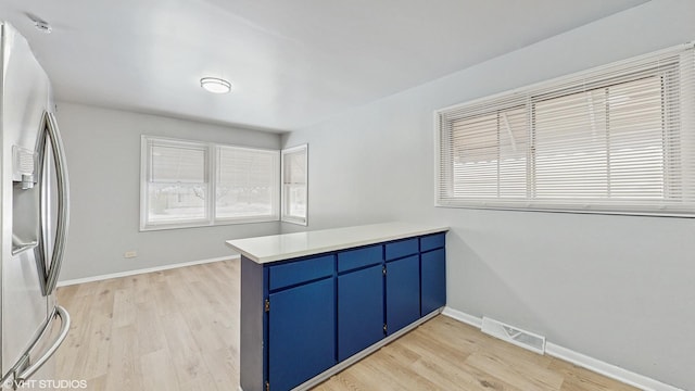 kitchen featuring light hardwood / wood-style floors, stainless steel fridge with ice dispenser, and kitchen peninsula