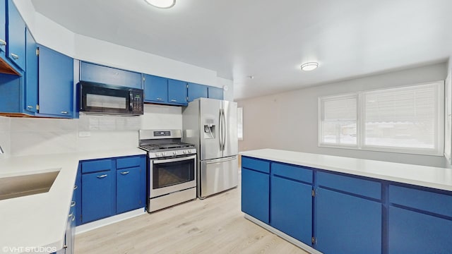 kitchen featuring blue cabinets, sink, appliances with stainless steel finishes, and light hardwood / wood-style flooring