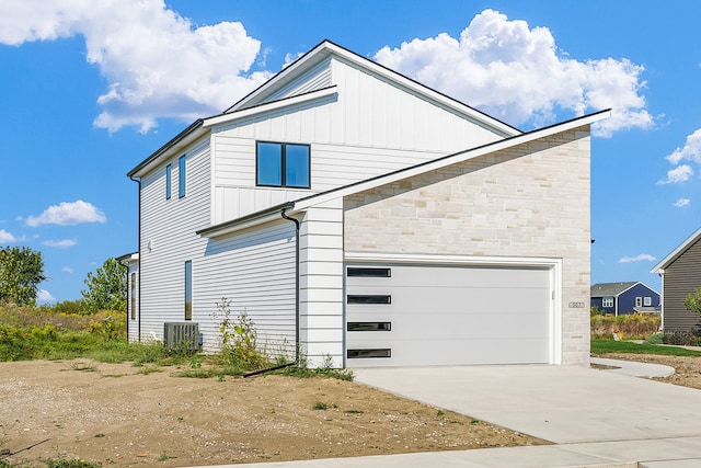 view of front of property featuring a garage and central AC