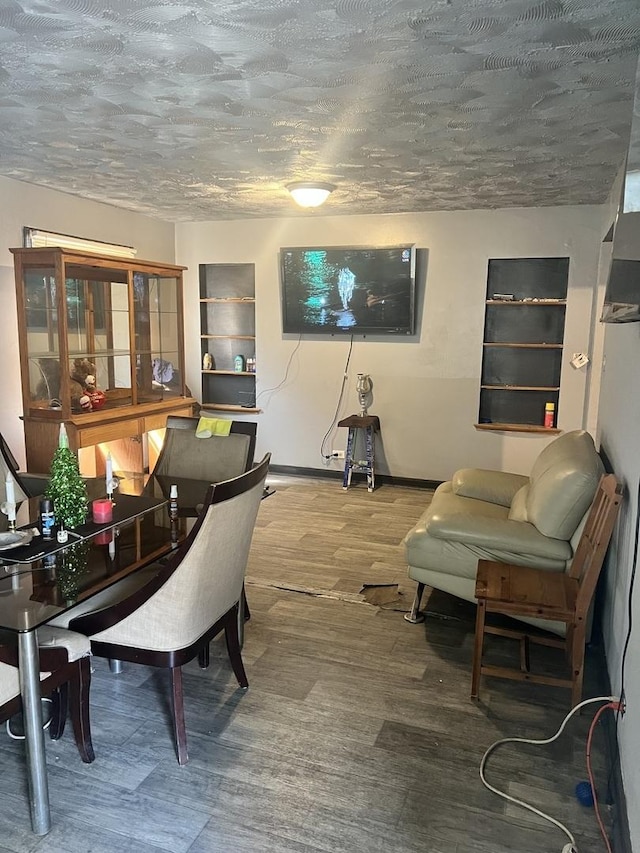 living room featuring wood finished floors, baseboards, and a textured ceiling