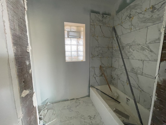 bathroom featuring tile patterned floors and tiled shower / bath