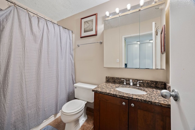 bathroom with a textured ceiling, toilet, tile patterned floors, and vanity