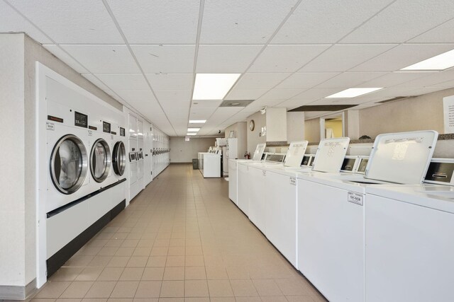 clothes washing area featuring light tile patterned floors and separate washer and dryer