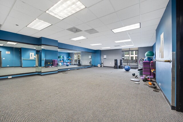 exercise room with a paneled ceiling and carpet flooring