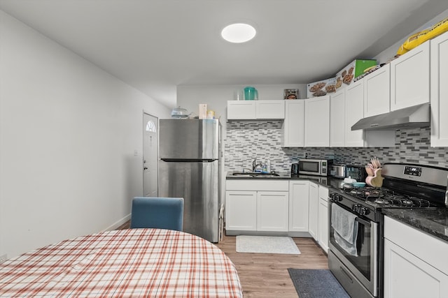 kitchen with light hardwood / wood-style flooring, backsplash, wall chimney range hood, and stainless steel appliances