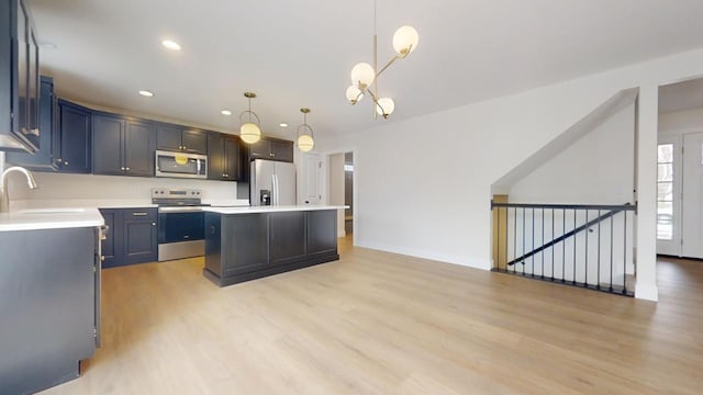 kitchen with stainless steel appliances, sink, light hardwood / wood-style flooring, a center island, and hanging light fixtures