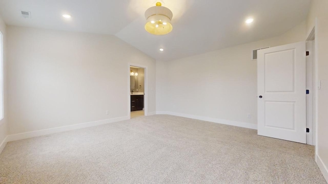 unfurnished room featuring light colored carpet and lofted ceiling