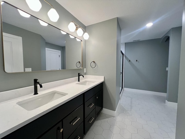 bathroom with a shower, vanity, and tile patterned floors