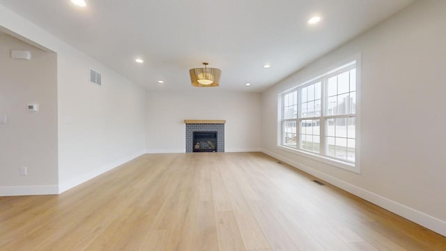 unfurnished living room with a fireplace and light hardwood / wood-style flooring