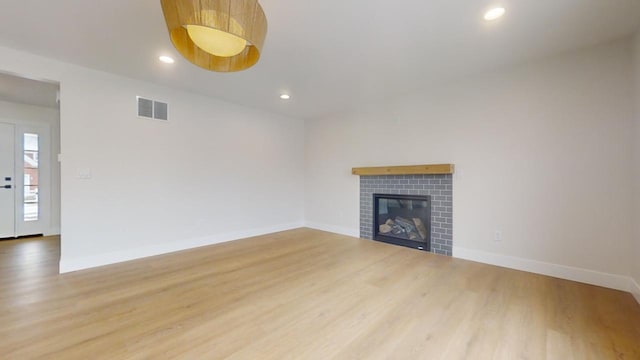 unfurnished living room featuring a fireplace and hardwood / wood-style flooring